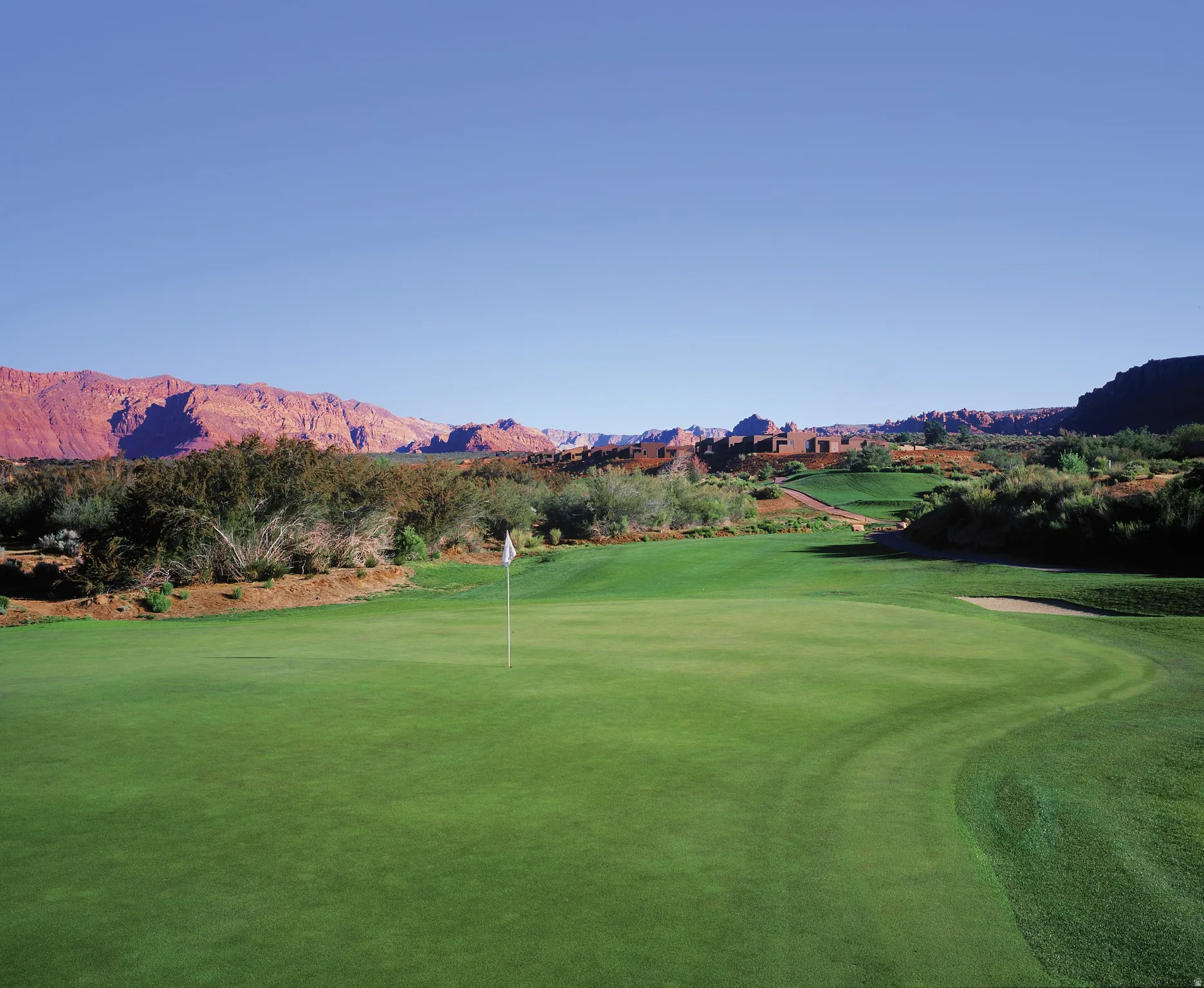 Expansive golf course green with manicured turf and a flagstick