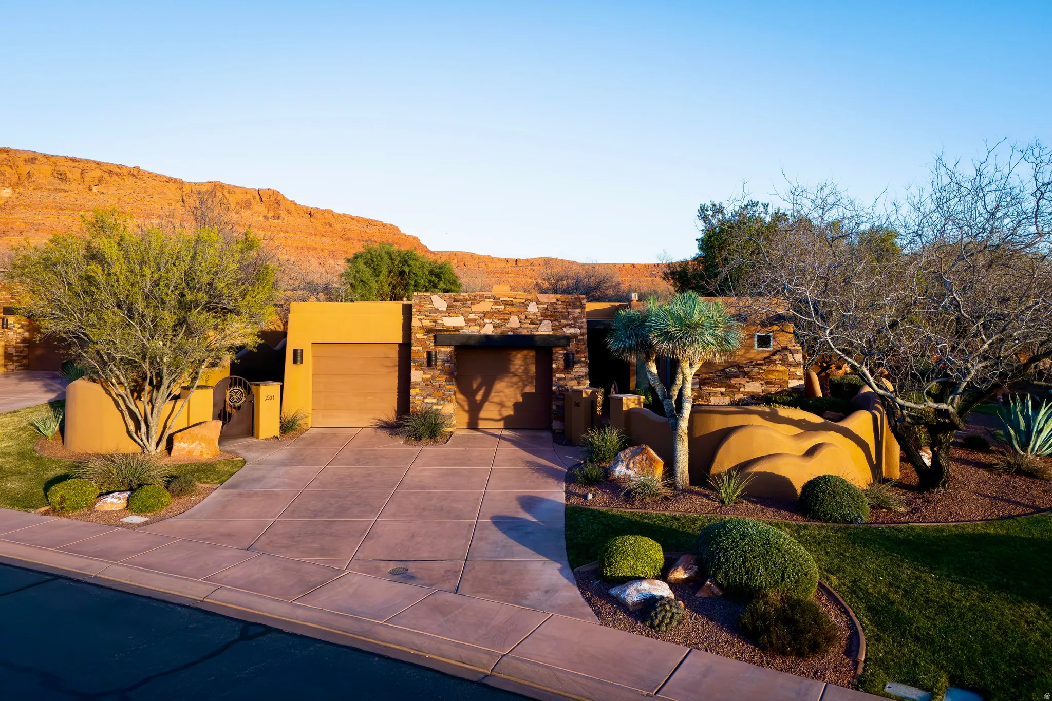 Southwestern style exterior with a stone facade, stucco walls, and an integrated garage
