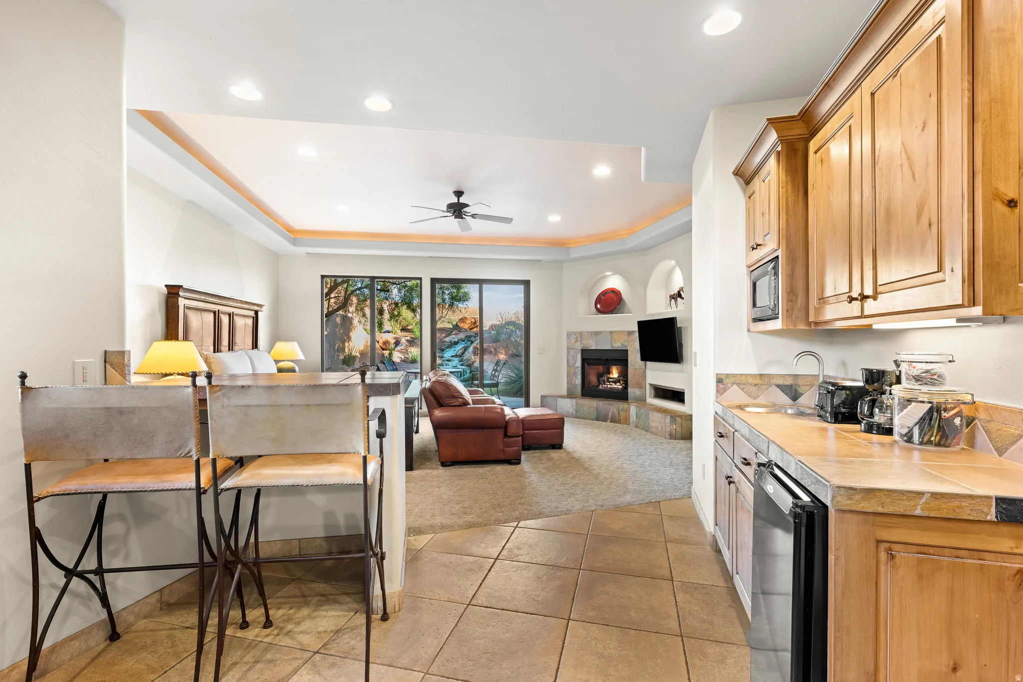 Recessed lighting, wood-finish cabinetry, tile flooring, built-in fireplace, and large sliding glass doors