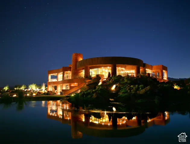 Architectural residence featuring a curved exterior, extensive fenestration, multiple balconies, and integrated exterior lighting