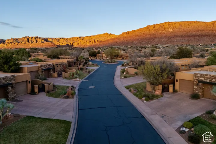 Residential neighborhood featuring desert landscaping, paved streets, and a mountainous backdrop