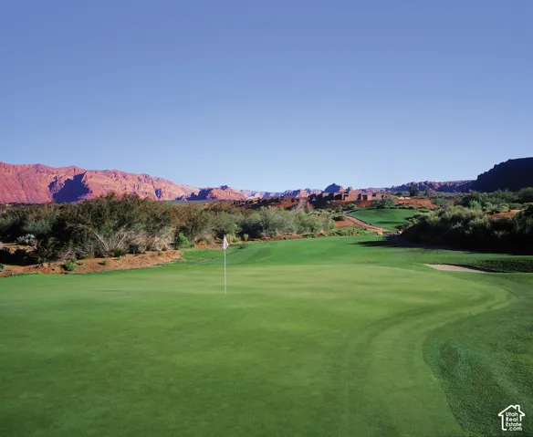 Expansive golf course green with manicured turf and a flagstick