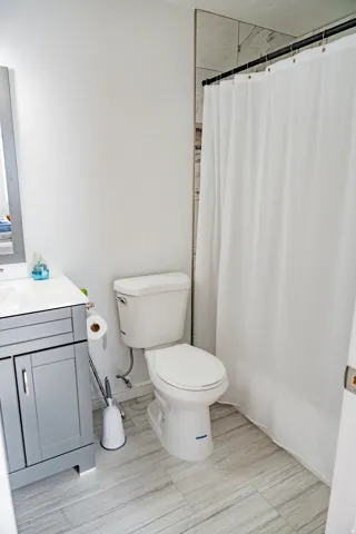 Modern vanity with a light gray finish, solid surface countertop, and undermount sink