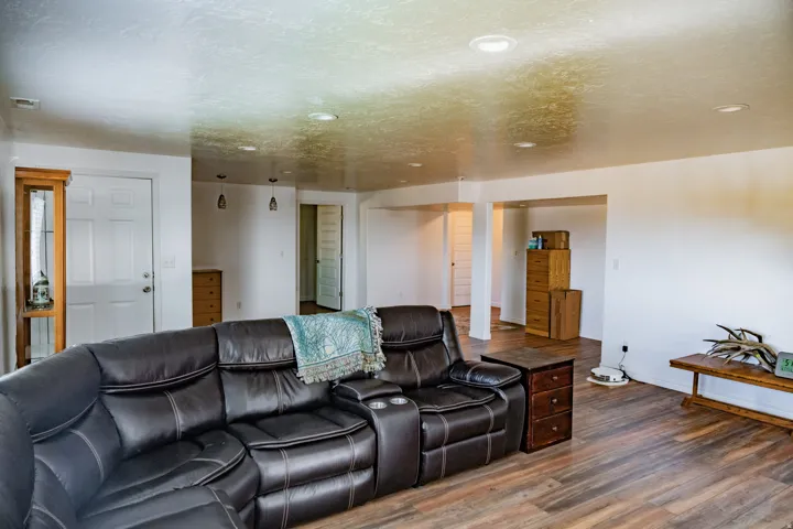 Recessed ceiling lighting, wood-finish flooring, and white interior doors