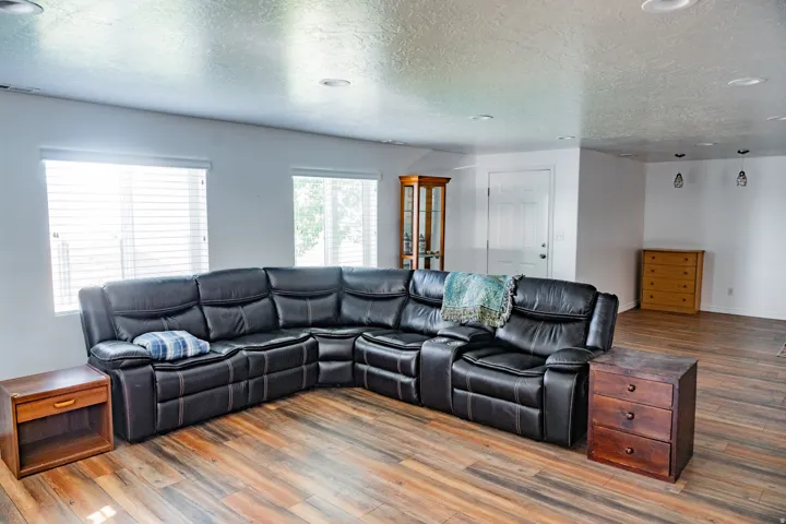 Recessed ceiling lighting, wood-finish flooring, and multiple windows with horizontal blinds