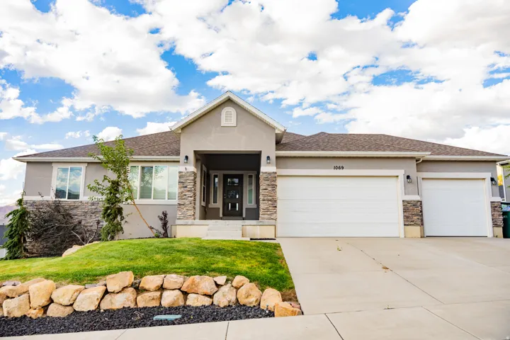 Stucco exterior with stone accents and a covered entry