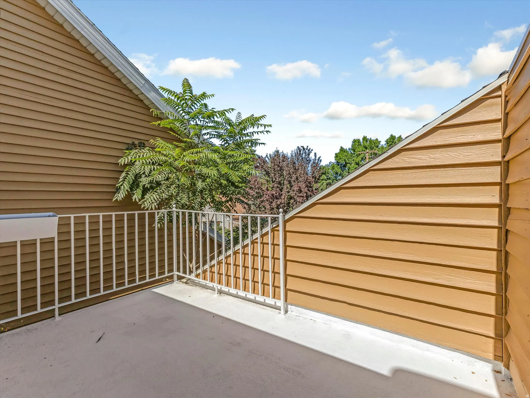 Private outdoor patio off the master suite with a white metal railing