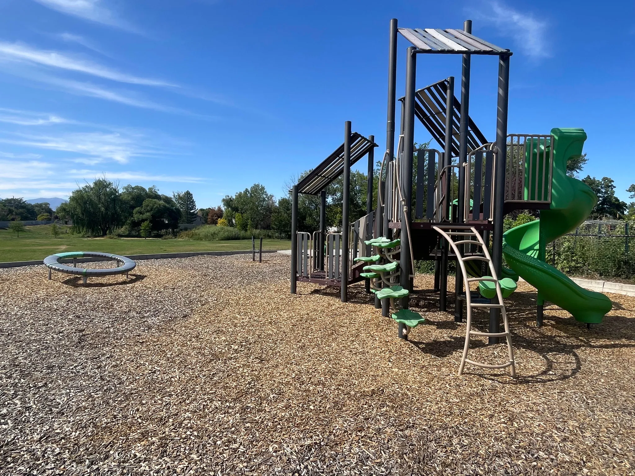 Neighboring Scott Avenue Park - playground featuring a multi-level play structure, green spiral slide, and climbing ladder
