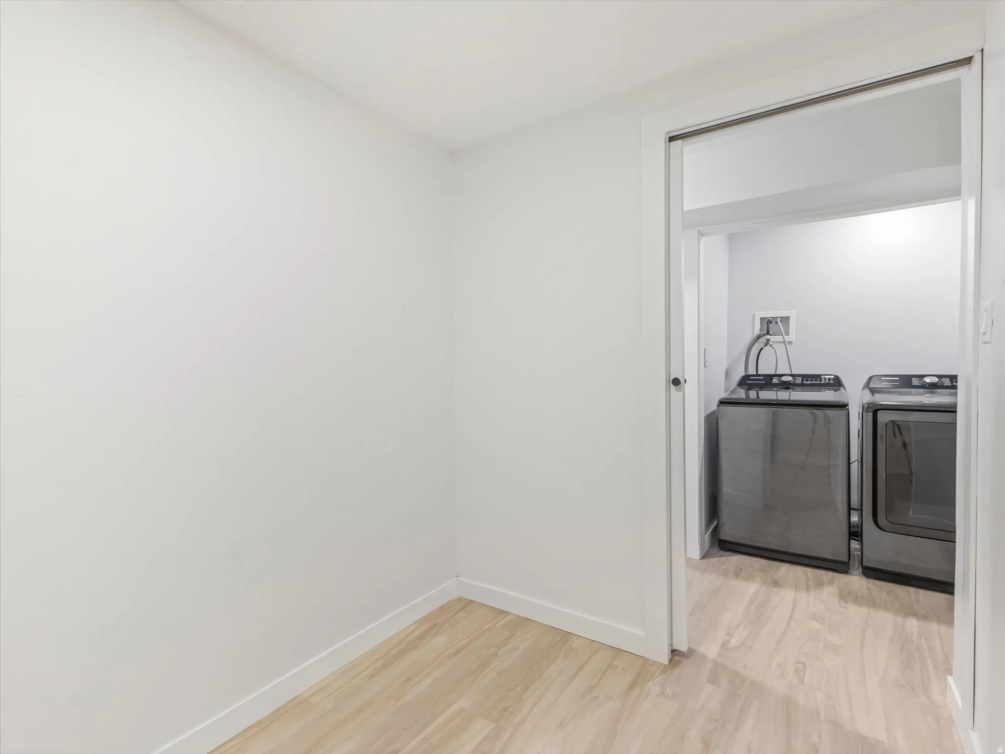View from basement Office into Laundry area with light LVP flooring