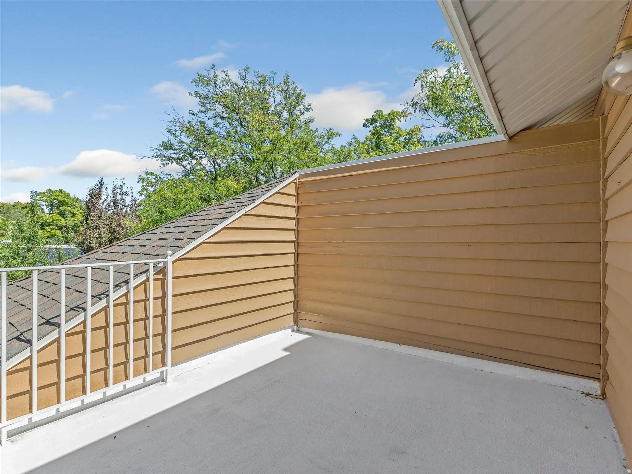 Private outdoor patio off the master suite with a white metal railing