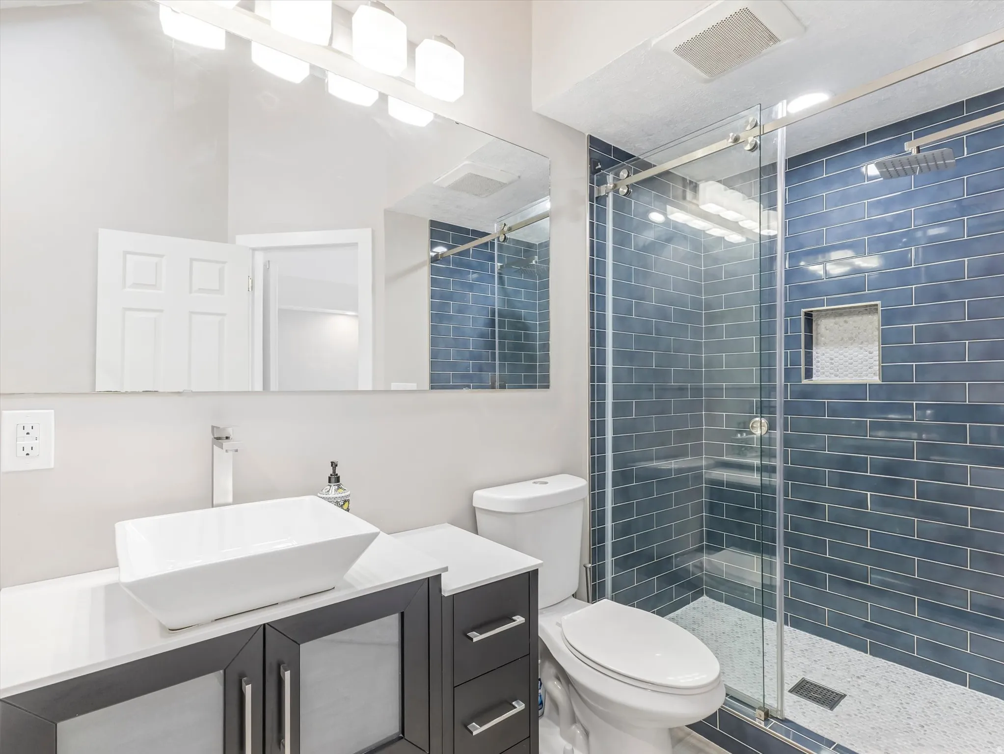 Master Bath with Modern bathroom featuring a glass-enclosed shower with blue subway tile surround