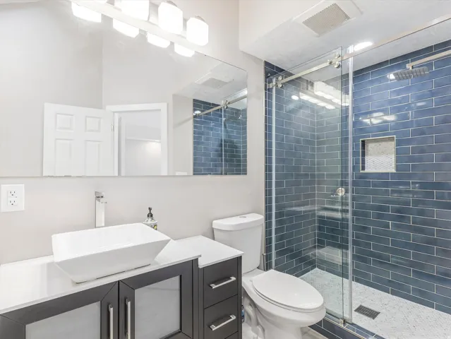 Master Bath with Modern bathroom featuring a glass-enclosed shower with blue subway tile surround