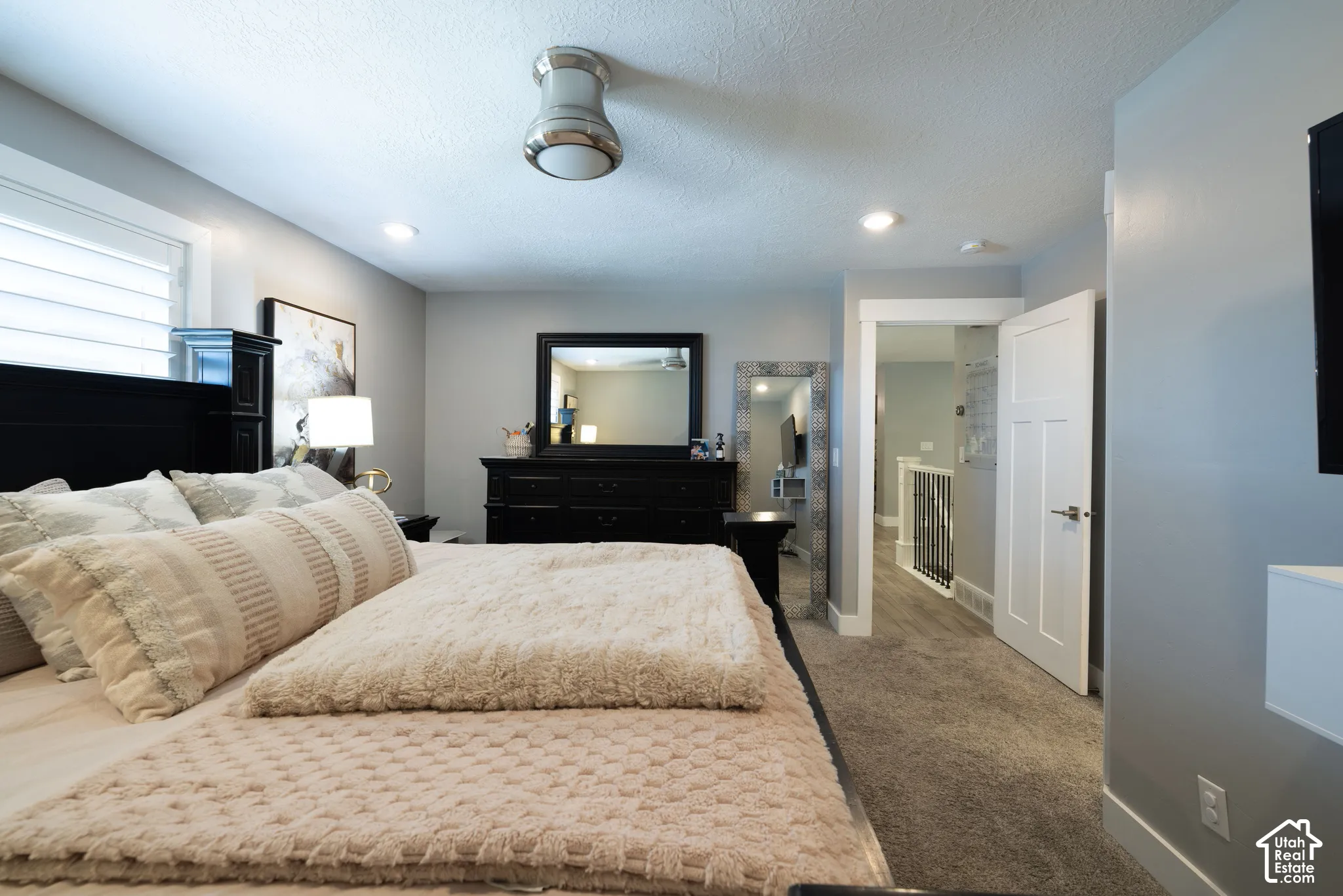 Recessed lighting, ceiling-mounted light fixture, carpeted flooring, white interior door, and window with horizontal blinds