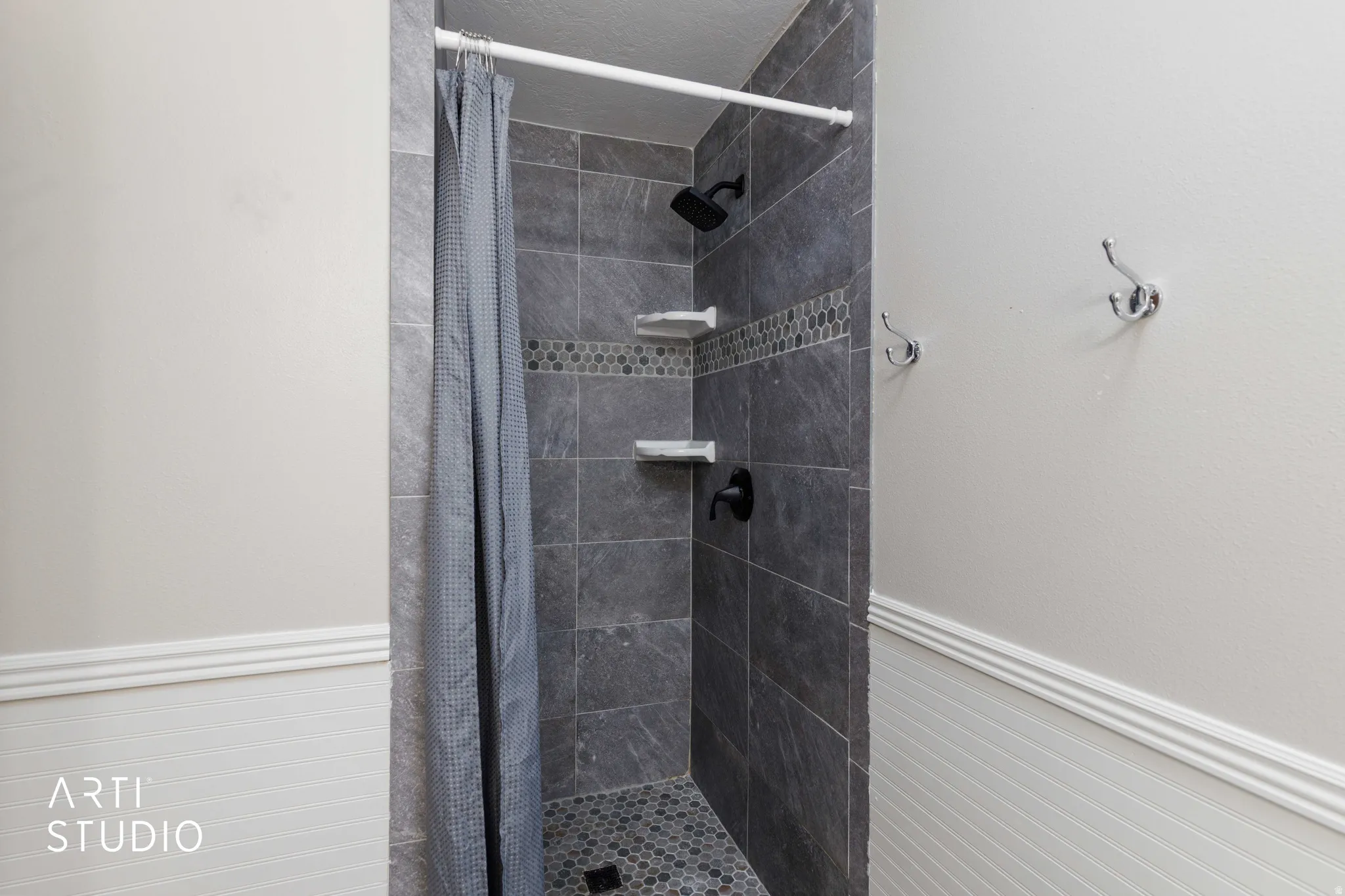 Master Shower with large format gray wall tile, decorative mosaic accent tile, and a hexagonal floor tile