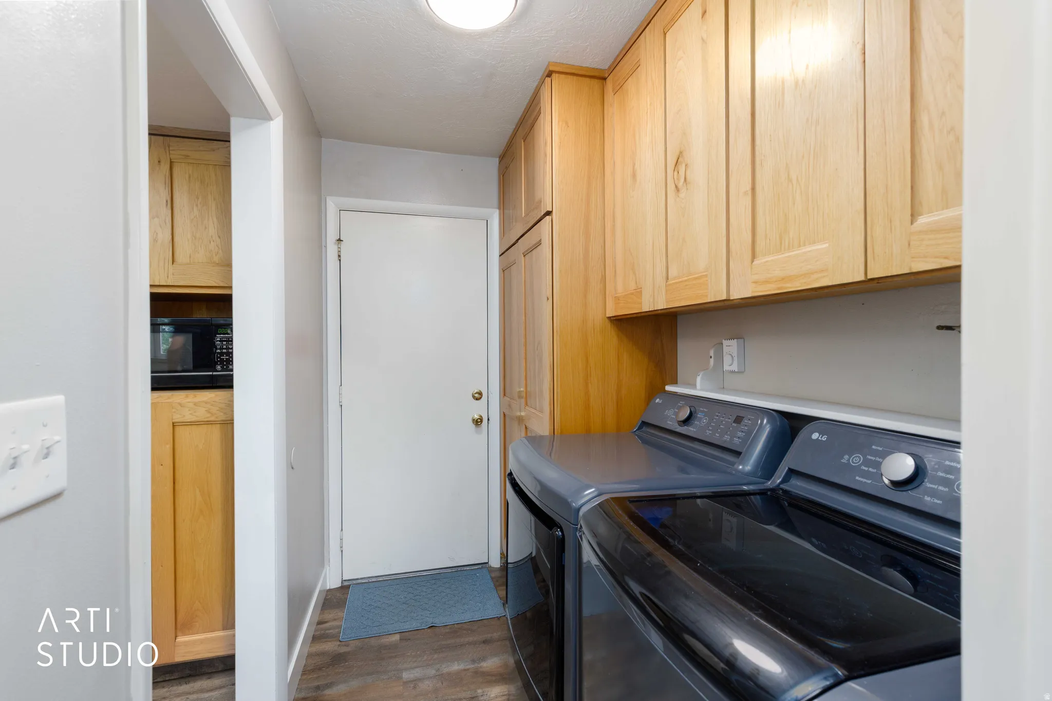 Built-in wood cabinetry, wood-finish flooring, and a flush-mount overhead light fixture