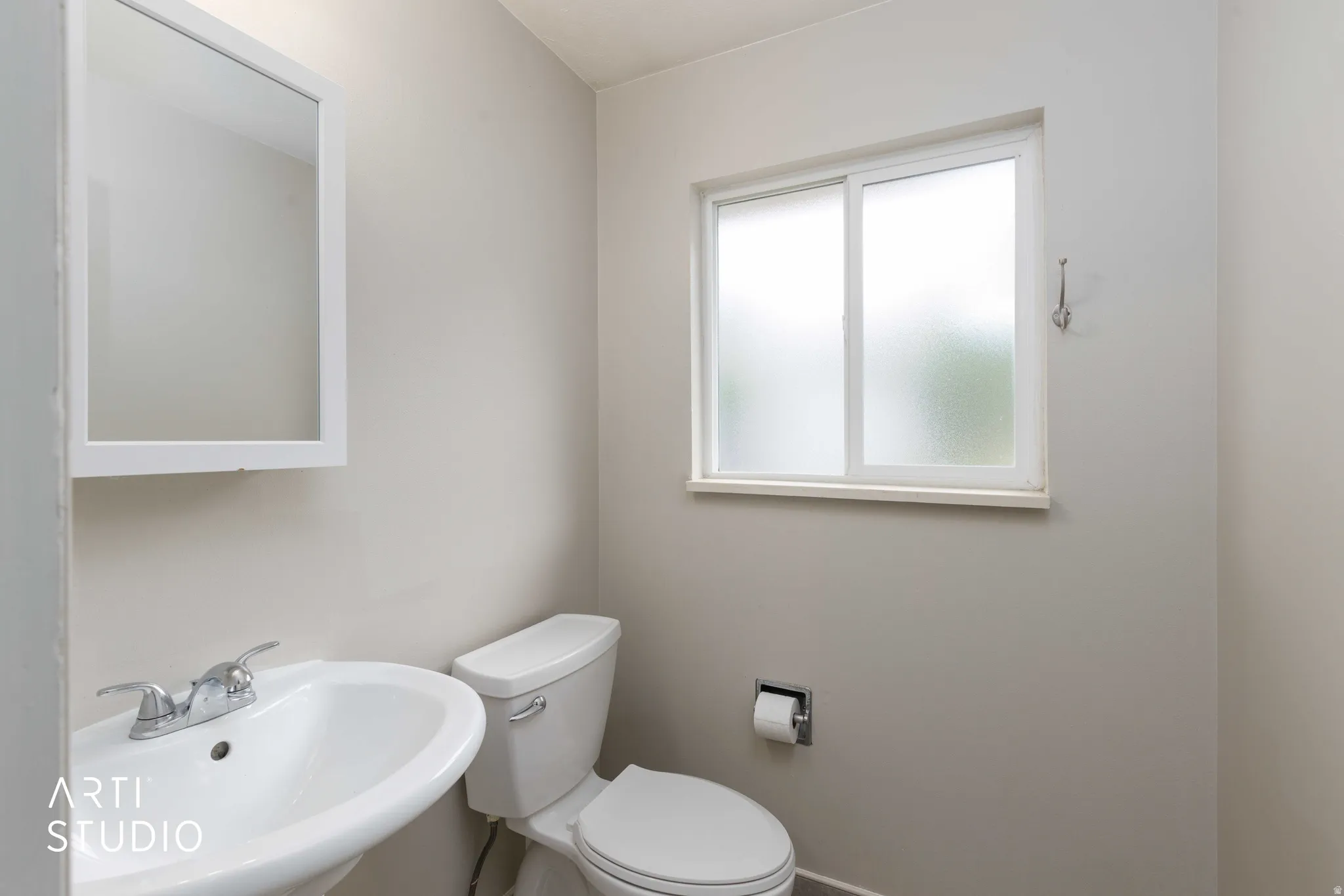 Half bath off  adjacent to kitchen featuring pedestal sink.