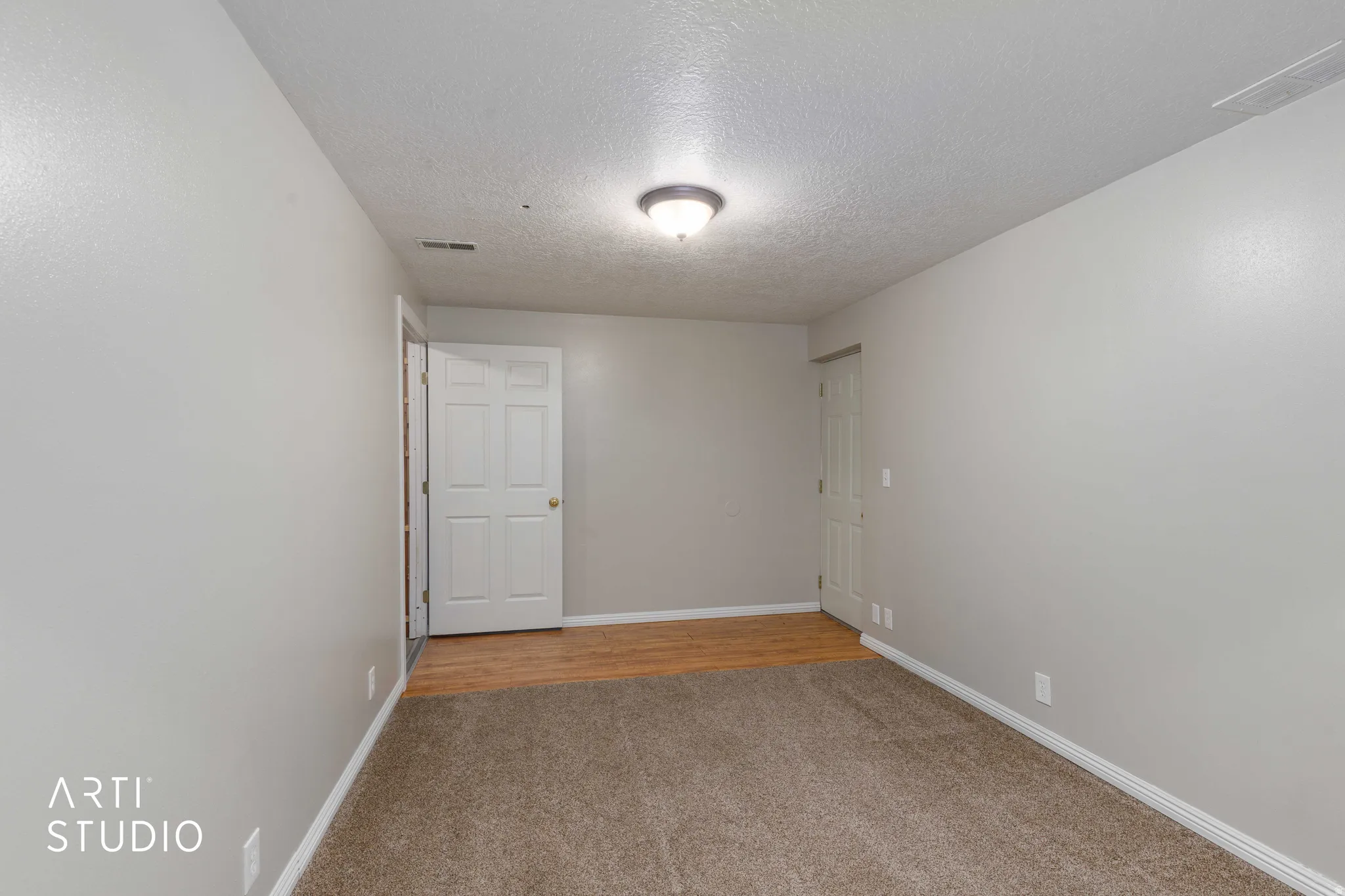 Neutral wall finishes, recessed lighting, and mixed flooring with carpeting and wood-finish sections