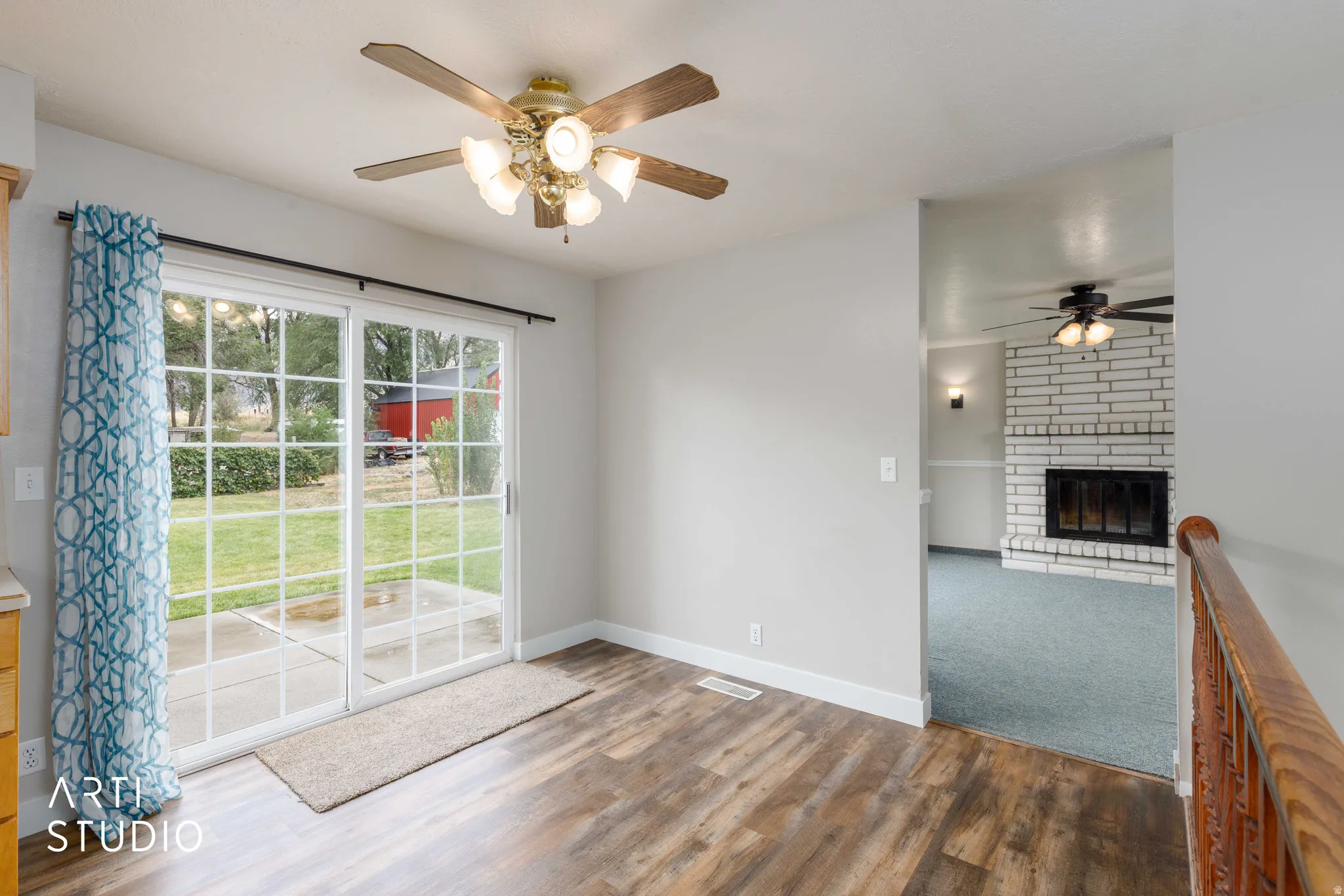 Sliding glass patio door with grid panes, wood-finish flooring, and a ceiling fan with integrated lighting