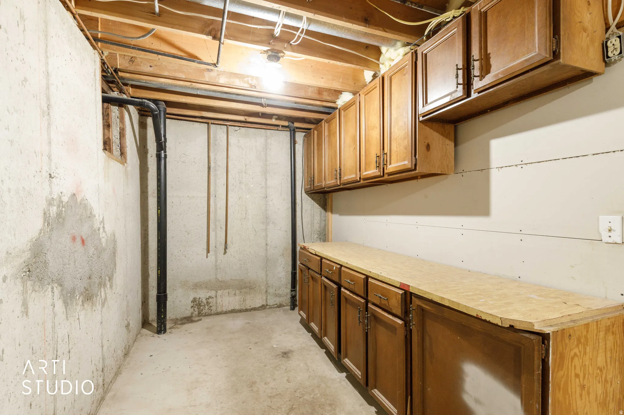 Hardwood cabinetry with matching upper and lower storage, and plumbing for additional kitchenette