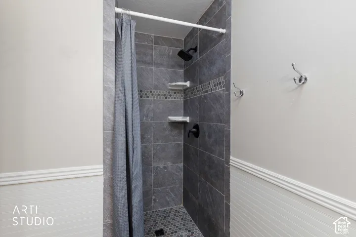 Master Shower with large format gray wall tile, decorative mosaic accent tile, and a hexagonal floor tile