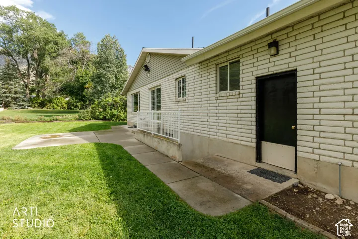 Brick exterior with white mortar, concrete patio, and a grassy yard