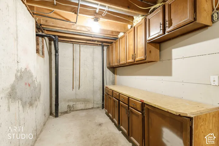 Hardwood cabinetry with matching upper and lower storage, and plumbing for additional kitchenette