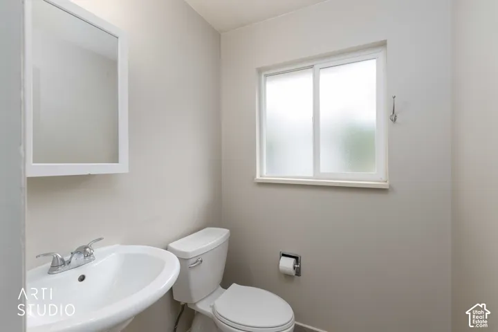 Half bath off  adjacent to kitchen featuring pedestal sink.
