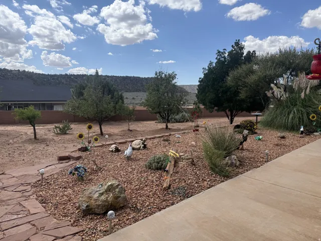 Xeriscaped garden bed featuring gravel and various plantings, alongside a flagstone pathway