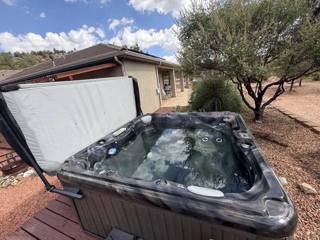 Black marbled hot tub with jets on a wood-finish deck