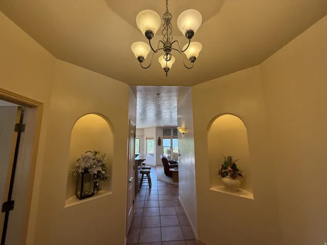 Recessed wall niches with interior lighting, tile flooring, and an ornate ceiling light fixture