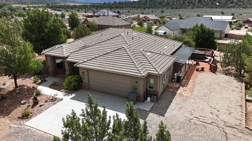 Attached garage, covered front entry, tile roof, private patio, and gravel landscaping
