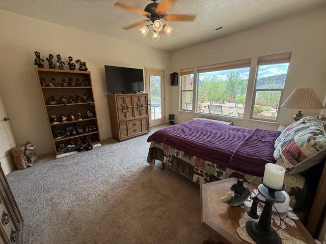 Recessed lighting, ceiling fan with integrated lighting, carpet flooring, multiple windows, and a glass-paneled door