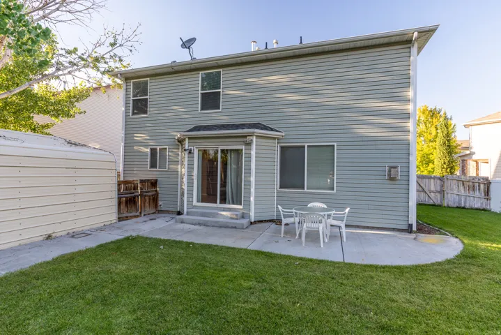 Sliding door from home to backyard, concrete patio, and lush lawn