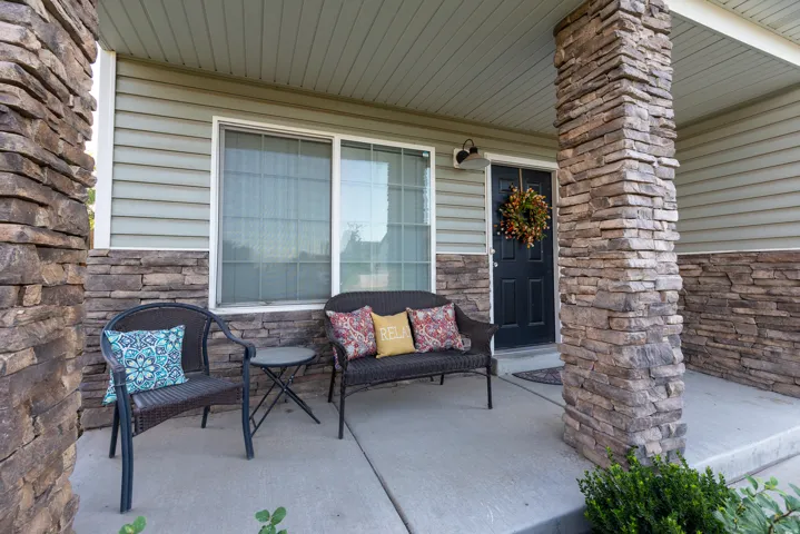 Stone veneer accents on columns and lower facade, & covered front porch with views