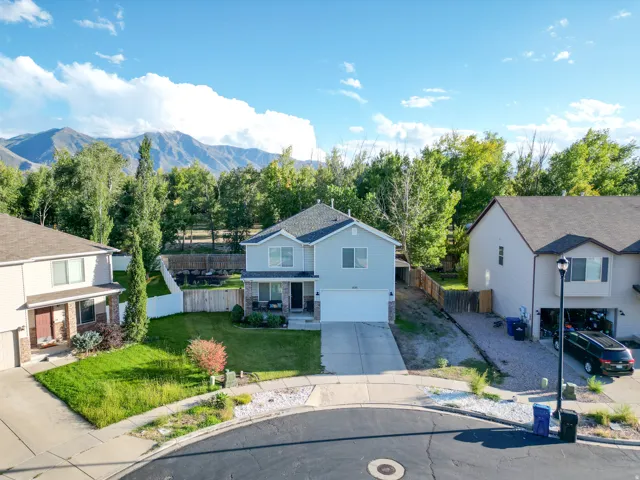 Two-story residence featuring a two-car garage, front porch, a fenced backyard, RV parking, & 2-car carport