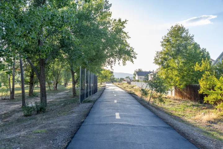 Paved Spanish Fork River Trail with beautiful views bordered by mature trees
