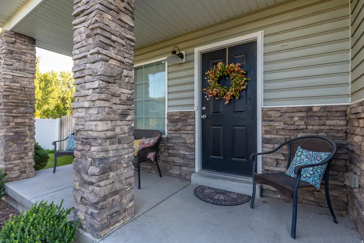 Front entrance featuring stacked stone columns, cozy front porch with views