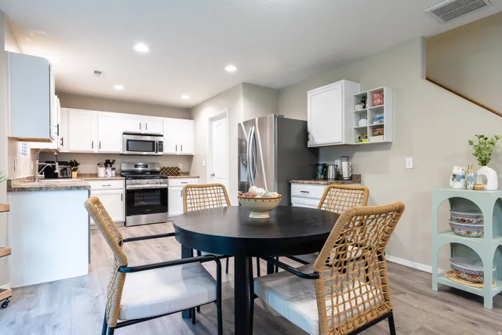 Kitchen featuring white cabinetry, newer stainless steel appliances, and wood-finish LVP flooring