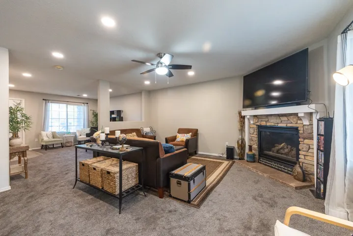 Lving room and Family room with stone-faced fireplace with mantel, and ceiling fan