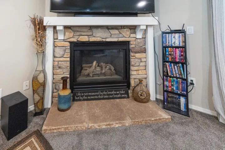 Stone-faced fireplace with a white mantel and hearth
