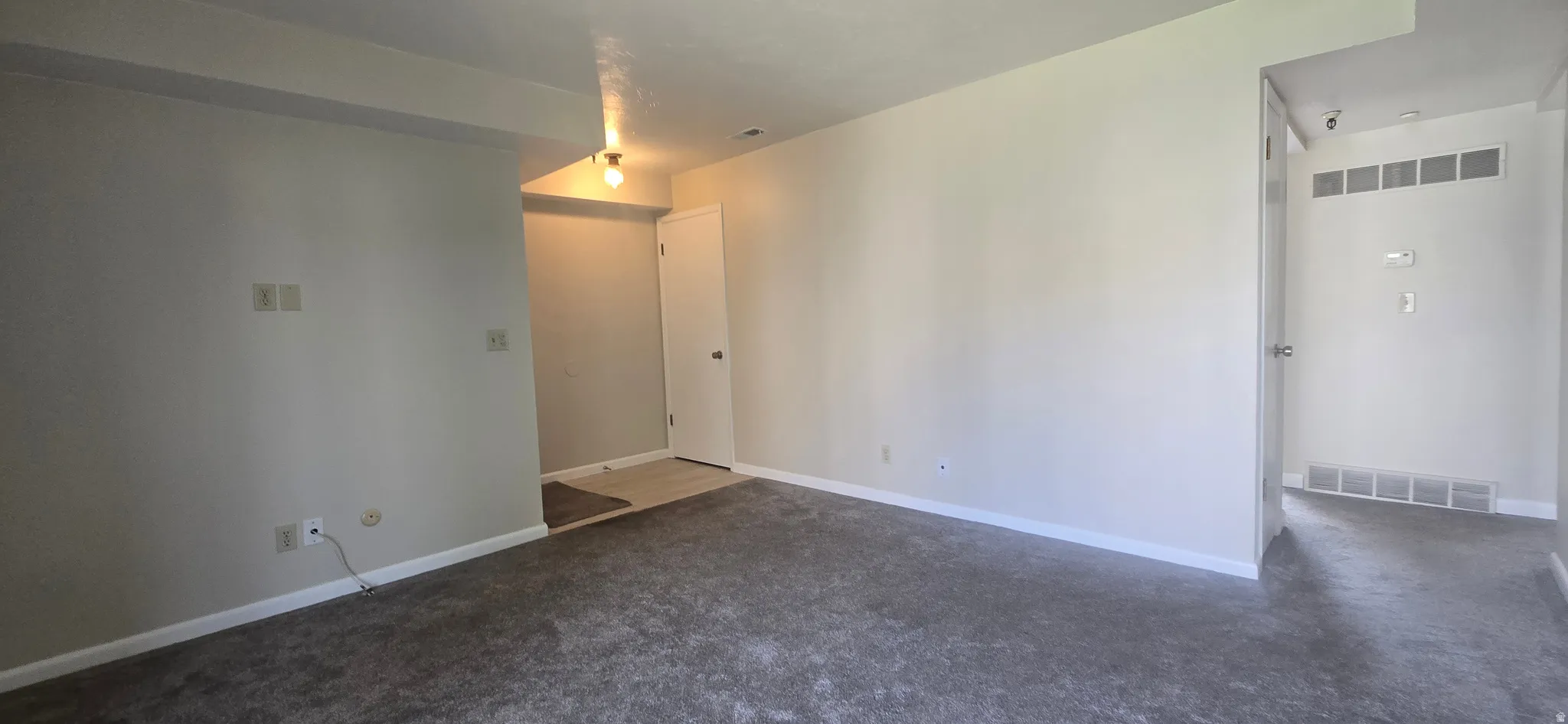 Carpeted flooring, neutral wall tones, interior door, overhead lighting, additional doorway