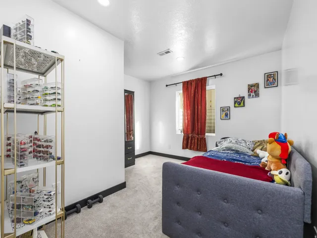 Recessed lighting, light gray carpeting, and a built-in closet with dark wood-finish doors