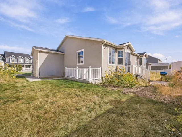 Stucco exterior, white vinyl railing, bay windows, and a paved walkway