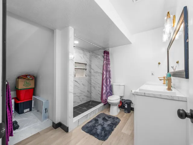 Walk-in shower with marble-look tile surround and dual recessed niches