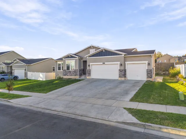 Contemporary stucco exterior with stone accents, a dual garage, and a concrete driveway