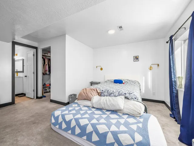 Carpeted flooring, recessed lighting, and wall-mounted sconces