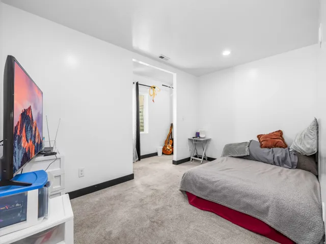 Carpeted flooring, white painted walls, recessed lighting, and black trim