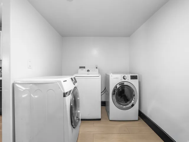 Dedicated laundry area featuring light-toned flooring and white walls