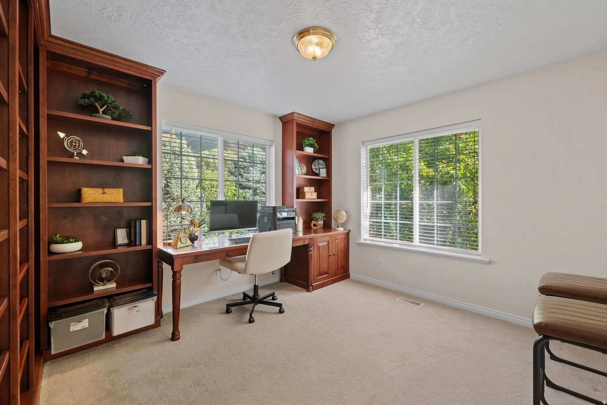 Built-in wood-finish shelving and desk with ample natural light from multiple windows