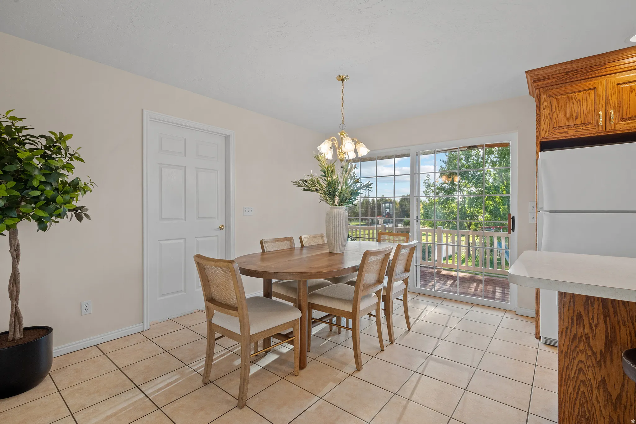 Tile flooring, sliding glass door, overhead lighting fixture, and oak cabinetry
